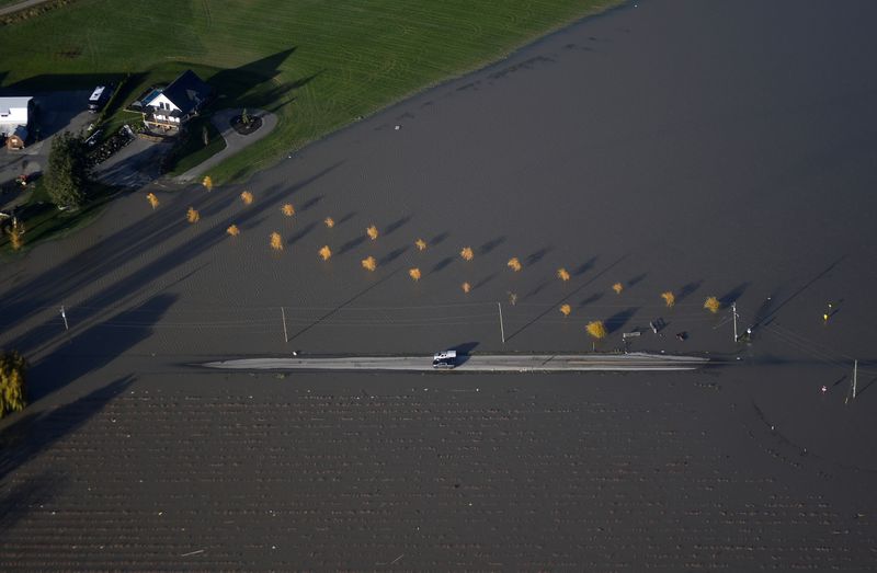 Economists cut Canada growth forecasts on floods, but see rate hikes on track
