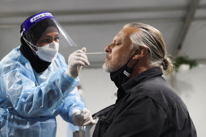 Australia records first Omicron death, authorities stick to reopening plan