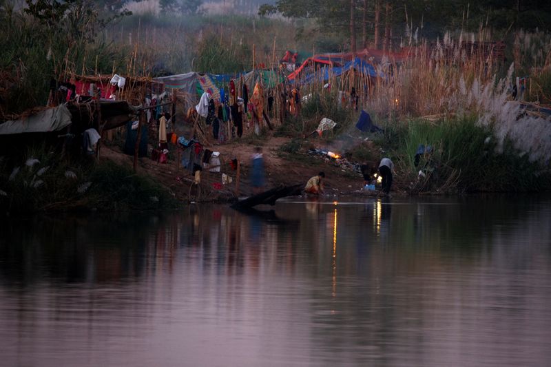 Fleeing violence in Myanmar, thousands camp along Thai border river