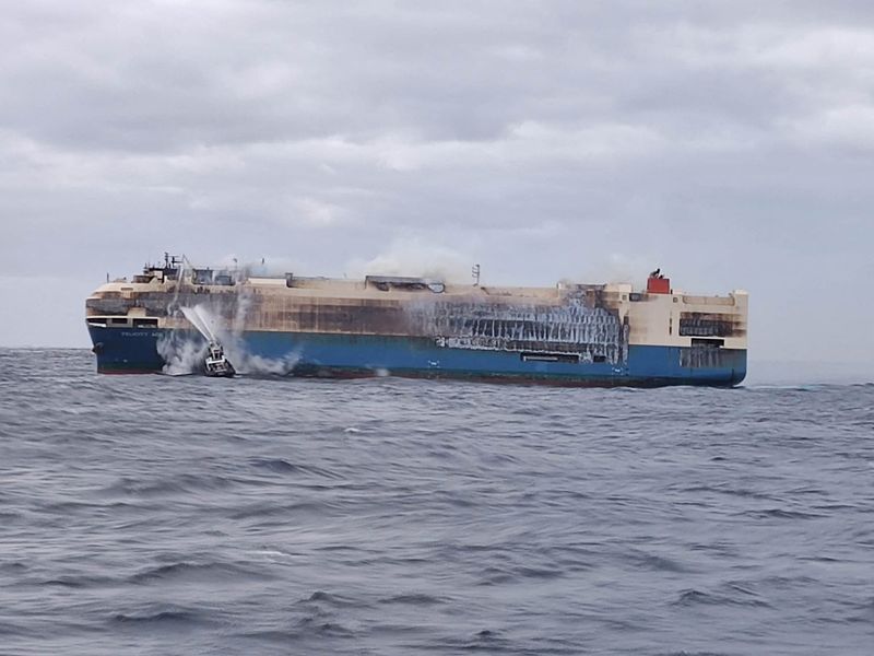 Rough seas delay salvage operation for burning ship carrying luxury cars